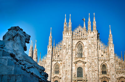 The golden sunshine is reflecting on the front of the magnificent duomo di milano or milan cathedral