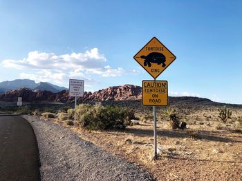 Information sign on road against sky