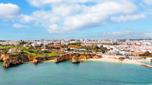 High angle view of townscape by sea against sky