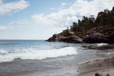 Large rocks and the splashing ocean against the beach