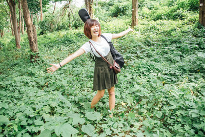 Rear view of young woman standing against plants