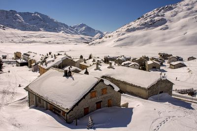 High angle view of snow covered village and mountains