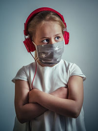 Portrait of boy standing against gray background