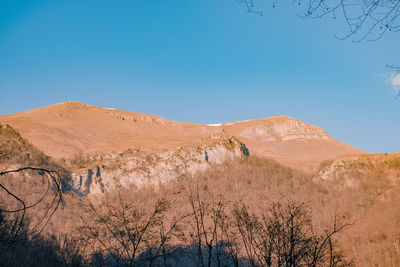 Scenic view of desert against clear blue sky