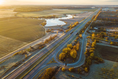 Aerial view of highway by field during sunrise