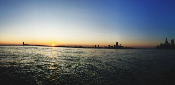 View of city at waterfront during sunset