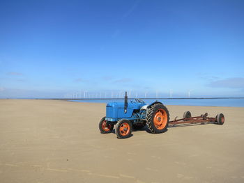 Motorcycle on beach against blue sky