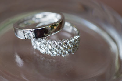 Close-up of wedding rings on glass table