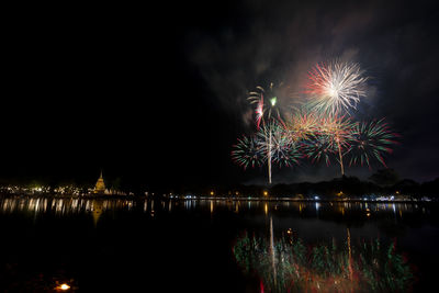 Firework display over river at night