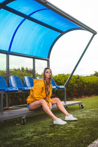 Portrait of a smiling young woman sitting on seat