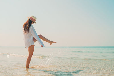 Woman splashing water on beach