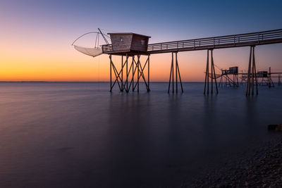 Typical old wooden fishing huts on stilts called  in the atlantic ocean at sunset.