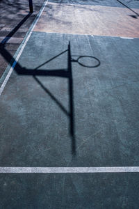 Street basketball hoop shadows on the court