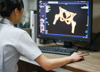 Rear view of woman working on table