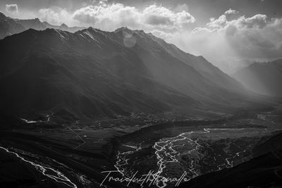 Aerial view of snowcapped mountain against cloudy sky