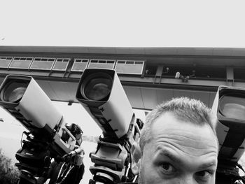 Close-up of man looking at camera against sky