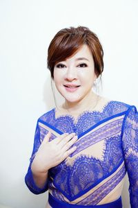 Portrait of smiling young woman against white background
