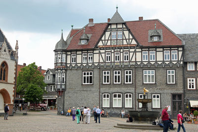 People on street against buildings in city