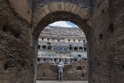 Rear view of male tourist visiting coliseum