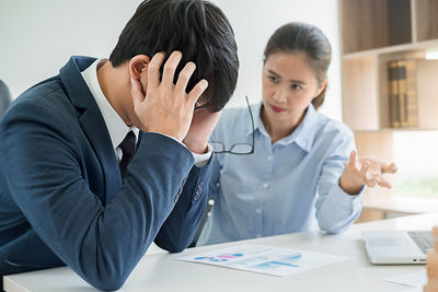 Businesswoman talking to stressed colleague in office