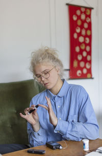 Young woman using glucometer