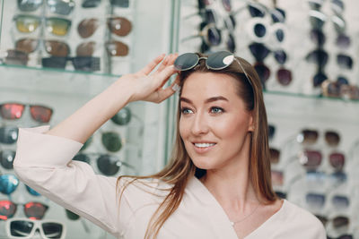 Young woman wearing sunglasses while standing in store