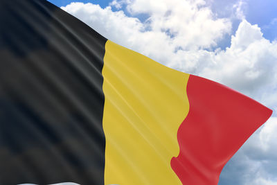 Low angle view of flag against yellow sky