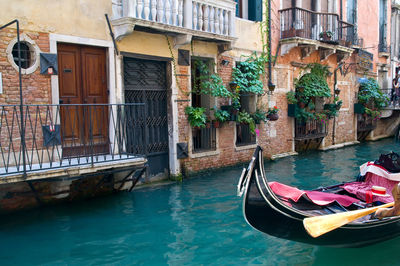 Romantic canal in venice with a black traditional gondola