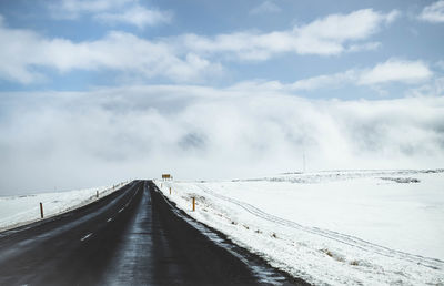 Snow covered road against sky