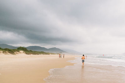 People on beach against sky