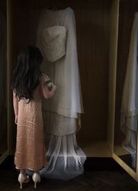 Rear view of girl standing at home