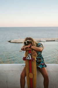 Young female with long board skate at sunset in moraira