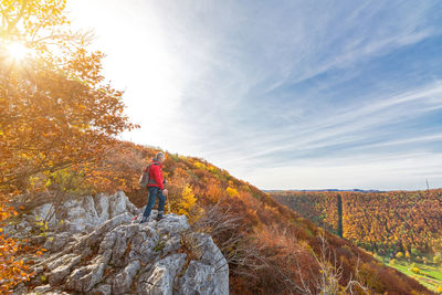 Full length of man standing on rock against sky