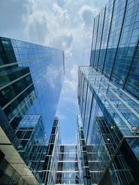 Low angle view of modern glass building against sky