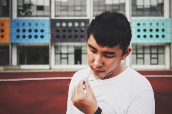 Sad young man looking at ring on necklace