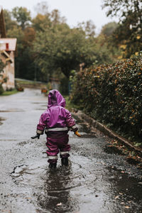 Toddler girl wading in puddle