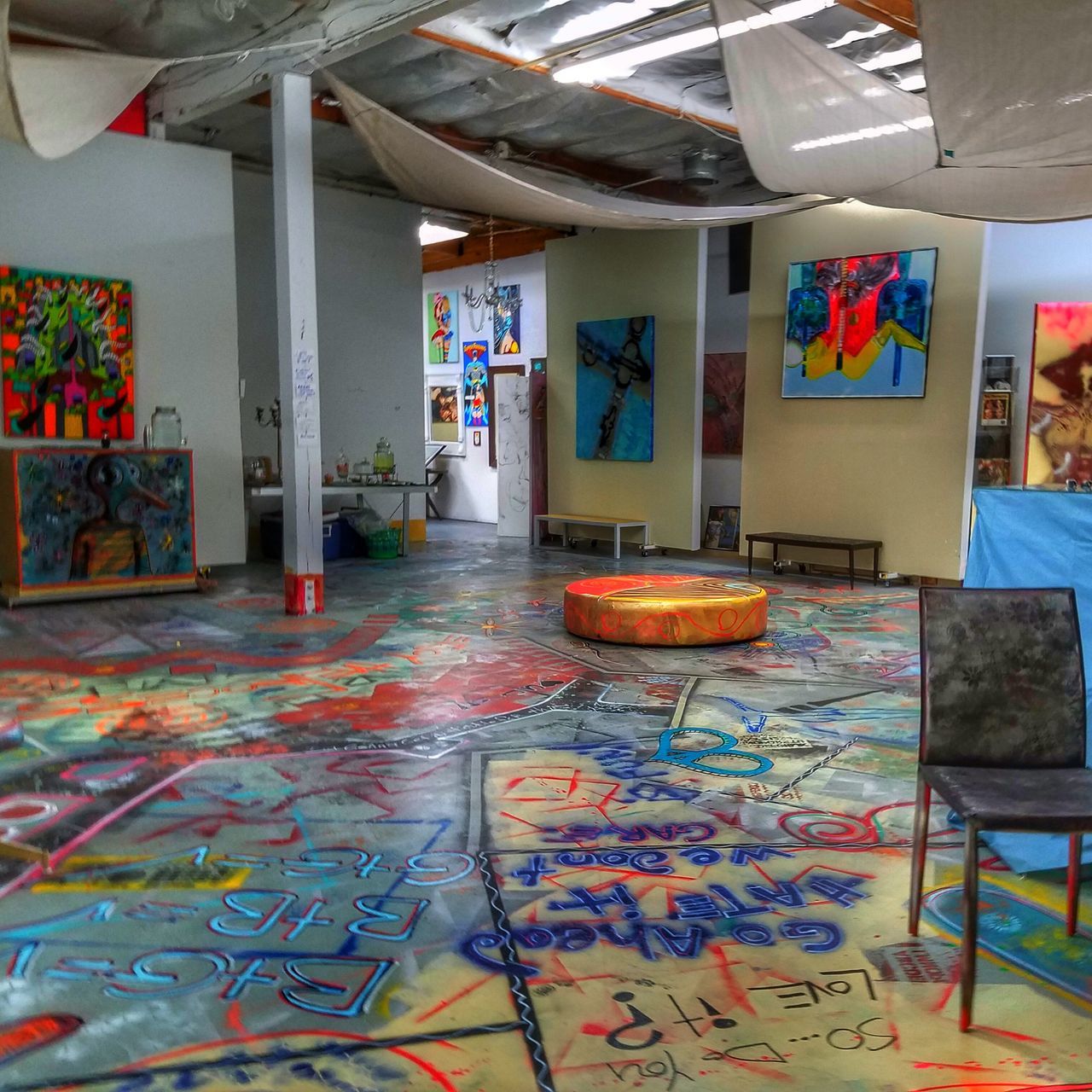 indoors, graffiti, built structure, architecture, empty, absence, multi colored, art and craft, messy, creativity, flooring, art, chair, wall - building feature, interior, no people, door, abandoned, house, day