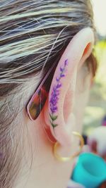 Close-up of woman with tattoo on ear