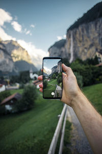 Man photographing through smart phone on mountain