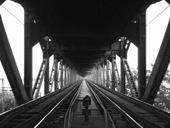 Rear view of woman walking on railroad bridge