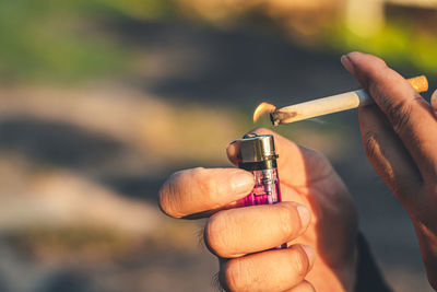 Close-up of hand holding cigarette