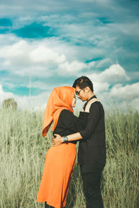 Young couple standing on field