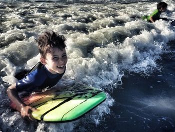 Portrait of boy surfing in sea