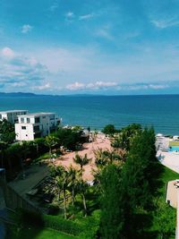 High angle view of town by sea against sky