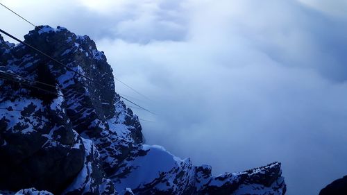 Low angle view of snow covered mountain against sky