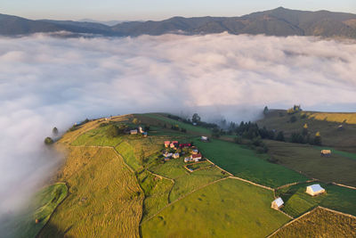 Scenic view of landscape by cloudscape during sunset