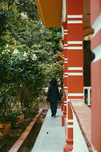 Rear view of girl walking by house