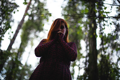 Low angle view of woman standing in forest