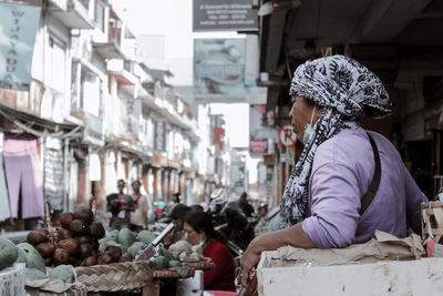 Woman for sale at market stall