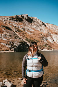 Scenic view of woman standing near lake after hiking